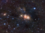 nurserie d´étoiles Cette région de formation d’étoiles, connue sous le nom de Monoceros R2, est enfouie dans un gigantesque nuage sombre. Elle est pratiquement entièrement voilée par de la poussière interstellaire quand on la regarde en lumière visible, mais elle est spectaculaire dans l’infrarouge.