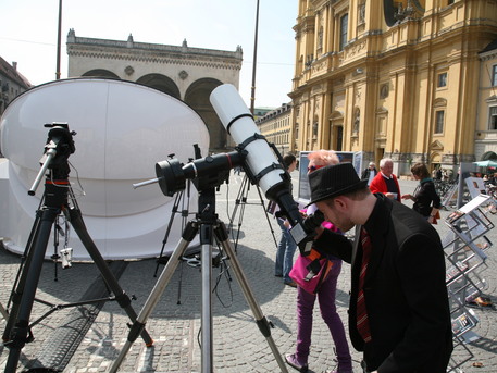 Die ersten Passanten schauen durch die auf dem Odeonsplatz aufgebauten Teleskope in die Sonne.