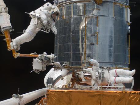 The picture was taken during the third spacewalk and shows the astronauts working on the giant telescope.