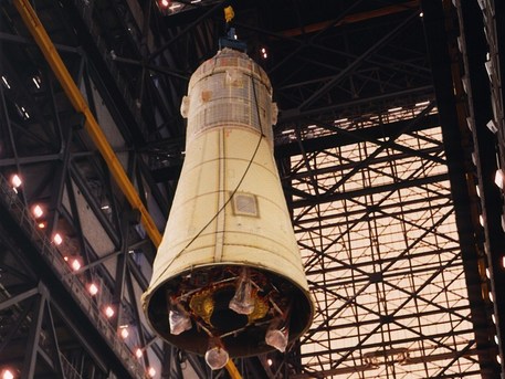 1. Mai 1969: Die komplette Kombination aus Mondlandefähre und Apollo-Mutterschiff wird im Vehicle Assembly Building von Cape Canaveral auf die Spitze der Saturn 5 gehievt. Die Mondlandefähre ist fast vollständig von der aerodynamischen Verkleidung der Raketenspitze verdeckt. Lediglich die (noch zusammengefalteten) Landebeine schauen unten heraus.


