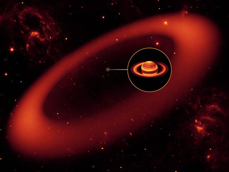 Neuer Saturnring Künstlerische Darstellung des bisher größten aller gefundenen Planetenringe. Dieser ist so dünn, dass er nur wenig Sonnenlicht reflektiert. Nur im Infrarotlicht konnte das Spitzer Weltraumteleskop ihn jetzt nachweisen. Zum Größenvergleich Saturn als kleiner Punkt im Zentrum des Ringes.