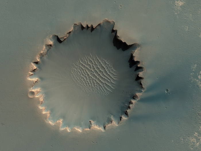 Der Victoria-Krater im Hochland Meridiani Planum. Er besitzt einen Durchmesser von etwa 800 Metern. Sedimentschichten und Felsen sind an seinem inneren Rand auszumachen. Letztere sind zum Teil sogar in das Zentrum des Kraters hinabgefallen. Der NASA Mars Rover Opportunity hat diesen Krater vor einigen Jahren besucht und untersucht.