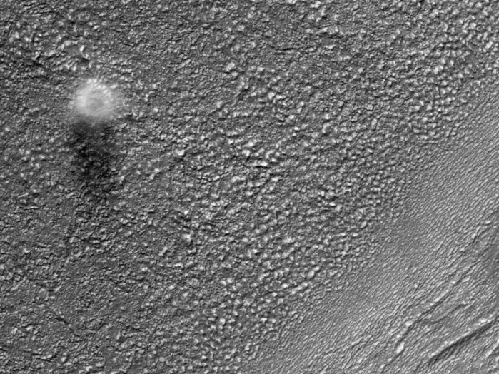 Dir Marskamera HiRISE hat hier einen Staub-Teufel eingefangen, der über die Marsoberfläche im Osten von der Hellas Einfluss-Waschschüssel und im Süden von Reull Vallis bläst. Der Durchmesser dieses Staub-Teufels ist ungefähr 200 Meter, aber an der Oberfläche ist er wahrscheinlich viel kleiner. Gestützt auf die Länge des Schattens in diesem Bild beträgt die Höhe des Staub-Teufels etwa 500 Meter.
