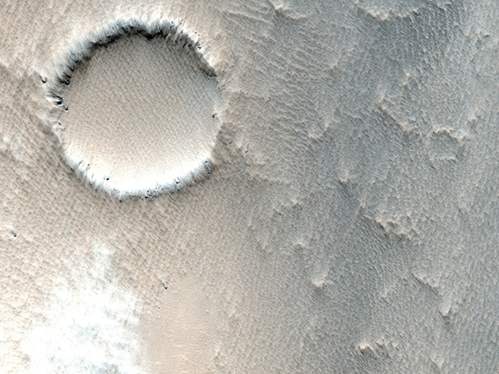 Ein kleiner Krater, der zum Teil schon von Ejekta aus anderen Einschlägen zugeweht wurde.
