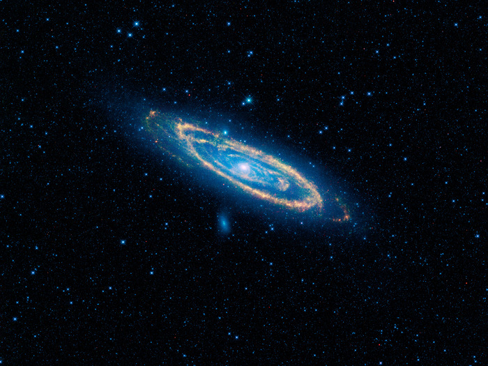 The immense Andromeda galaxy, also known as Messier 31 or simply M31, is captured in full in this new image from WISE. The mosaic covers an area equivalent to more than 100 full moons, or five degrees across the sky. WISE used all four of its infrared detectors to capture this picture (3.4- and 4.6-micron light is colored blue; 12-micron light is green; and 22-micron light is red). Blue highlights mature stars, while yellow and red show dust heated by newborn, massive stars.