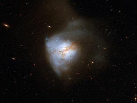 Arp 220 is a nearby example of a merged starburst galaxy similar to SMM J2135-0102. Located 250 million light-years from Earth, Arp 220 is the aftermath of a collision between two spiral galaxies. The collision, which began about 700 million years ago, has sparked a crackling burst of star formation. The star clusters are the bluish-white bright knots visible in the Hubble image. 
(c) NASA, ESA, the Hubble Heritage-ESA/Hubble Collaboration, and A. Evans (UVa/NRAO/Stony Brook)