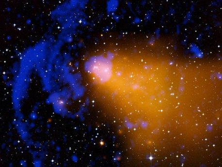 Composite image of the galaxy cluster Abell 3376 Two different teams have reported using Chandra observations of galaxy clusters to study the properties of gravity on cosmic scales and test Einstein's theory of General Relativity. Such studies are crucial for understanding the evolution of the universe, both in the past and the future, and for probing the nature of dark energy, one of the biggest mysteries in science.
This composite image of the galaxy cluster Abell 3376 shows X-ray data from the Chandra X-ray Observatory and the ROSAT telescope in gold, an optical image from the Digitized Sky Survey in red, green and blue, and a radio image from the VLA in blue. The "bullet-like" appearance of the X-ray data is caused by a merger, as material flows into the galaxy cluster from the right side. The giant radio arcs on the left side of the image may be caused by shock waves generated by this merger.