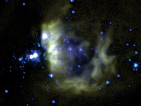 Mid-infrared image of BYF 73 from NASA's Spitzer Space Telescope. The yellowish wisps to the right are remnants of gas that have been heated and are being driven off by the massive young stars within them (seen in blue). The large-scale collapse of colder gas to form a massive cluster is centred around the bright stars just to the left of the heated wisps.