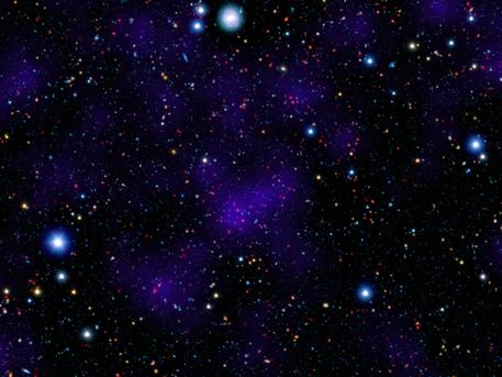 A surprisingly large collection of galaxies (red dots in center) stands out at a remarkably large distance in this composite image combining infrared and visible-light observations. NASA's Spitzer Space Telescope contributed to the infrared component of the observations, while shorter-wavelength infrared and visible data are provided by Japan's Subaru telescope atop Mauna Kea, Hawaii.
Looking out to this distance, the cluster appears as it was 9.6 billion years ago, only about three billion years after the Big Bang. Astronomers were surprised to find such a "modern" cluster at an era when its peers tended to be much smaller, presumably taking billions of more years to collect enough galaxies to reach such a size.