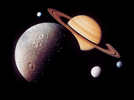 This montage of images of the Saturnian system was prepared from images taken by the US Voyager 1 spacecraft during its Saturn encounter in November 1980. This artist's arrangement shows Dione in the foreground, Saturn rising behind, Tethys and Mimas fading in the distance to the right and Enceladus to the left