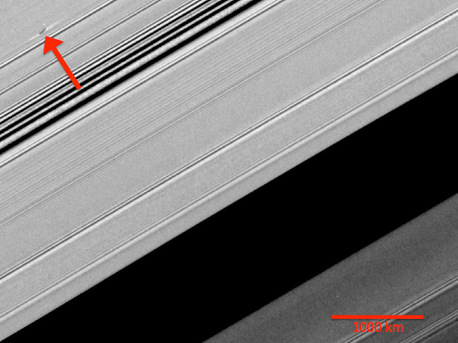 A propeller-shaped structure created by an unseen moon appears dark in this image obtained by NASA's Cassini spacecraft of the unilluminated side of Saturn's rings. 