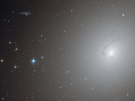 This picture, taken by Hubble’s Advanced Camera for Surveys, shows NGC 4696, the largest galaxy in the Centaurus Cluster.

The huge dust lane, around 30 000 light-years across, that sweeps across the face of the galaxy makes NGC 4696 look different from most other elliptical galaxies. Viewed at certain wavelengths, strange thin filaments of ionised hydrogen are visible within it. In this picture, these structures are visible as a subtle marbling effect across the galaxy’s bright centre.