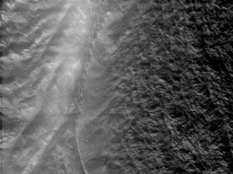 Senkrecht nach unten in die Eruptionsspalte "Damascus Sulcus" geht der Blick der Raumsonde Cassini bei ihrer dichtesten Annäherung am 13. August 2010. Das Bild entstand aus einem Abstand von 2600 Kilometern und zeigt Details bis hinab zu 15 Meter Durchmesser. Der feine "Nebel" im linken Bereich des Bildes sind tatsächlich die Wasserdampfschwaden und Eispartikel, die an dieser Stelle in den Weltraum entweichen.