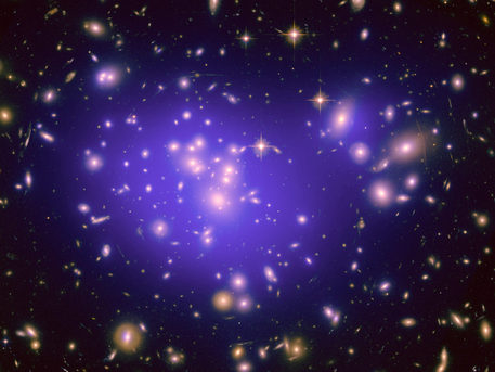 This is the Hubble Space Telescope image of the inner region of Abell 1689, an immense cluster of galaxies located 2.2 billion light-years away. Dark matter in the cluster is mapped by plotting the plethora of arcs produced by the light from background galaxies that is warped by the foreground cluster's gravitational field. Dark matter cannot be photographed, but its distribution is shown in the blue overlay. The dark matter concentration and distribution is then used to better understand the nature of dark energy, a pressure that is accelerating the expansion of the universe. The imaging data used in the natural-color photo was taken in 2002 with Hubble's Advanced Camera for Surveys.