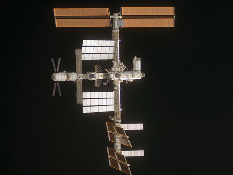 ATV Jules Verne docked with the International Space Station (ISS) in April 2008. This picture was taken from the Space Shuttle STS 124. The transporter, recognisable due to its X-shaped solar panels, can be seen on the left as an extension of the central axis of the ISS.