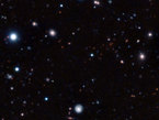 This image is a composite of very long exposures taken with ESO’s Very Large Telescope in Chile and the NAOJ’s Subaru telescope on Hawaii. Most of the visible objects are very faint and distant galaxies. The clump of faint red objects to the right of centre is the most remote mature cluster of galaxies yet found.