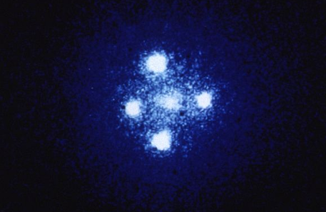 Das Einsteinkreuz: Hier wird das Licht eines Quasars durch einen Effekt der Allgemeinen Relativitätstheorie so abgelenkt, dass wir ihn gleich vier mal sehen.