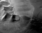 Gebirge in der östlichen Hellas-Region: Der Höhenzug ist umgeben von Ablagerungen mit Fließtexturen auf der Oberfläche. Bodenradarmessungen haben nun gezeigt, dass es sich um einen Gletscher handelt, der unter einer dünnen Gesteinslage begraben liegt.