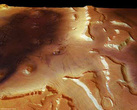 Dieses Foto der Marsregion Deuteronilus Mensae zeigt links im Bild den Rest eines alten Einschlagskraters, in den von rechts Täler einmünden. In ihnen lassen sich deutliche Fließspuren erkennen. Sie entstanden durch so genannte Blockgletscher - Eisströme 