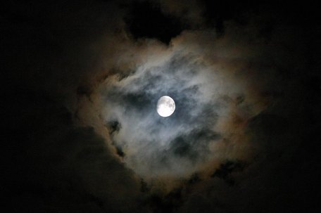 Dünne Wolken mit einem Hof um den Mond