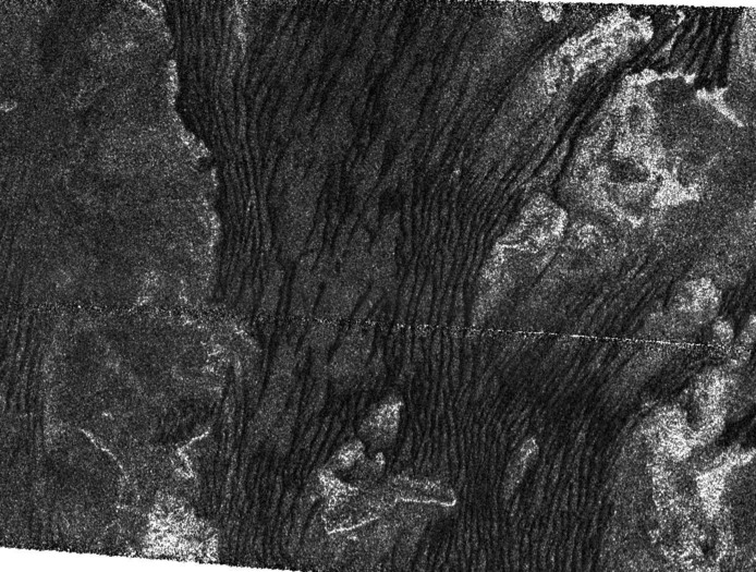 The area shown covers the southern boundary of an equatorial band where longitudinal dunes (dunes that form along the wind direction) are pervasive. Here the dunes are apparently created by winds locally coming from the west and north-west, and generally 